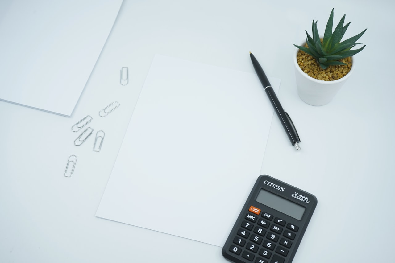 A calculator and pen resting on a sheet of paper